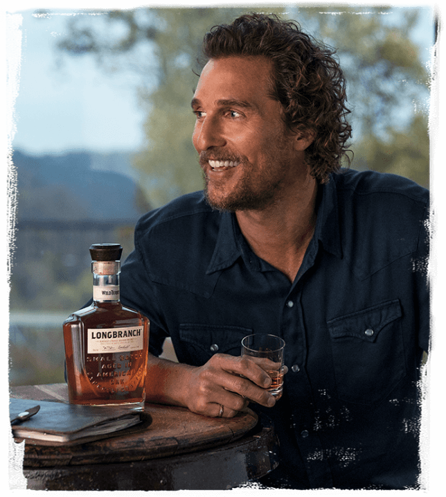 Matthew McConaughey przy stole ze szklaneczką Wild Turkey Longbranch